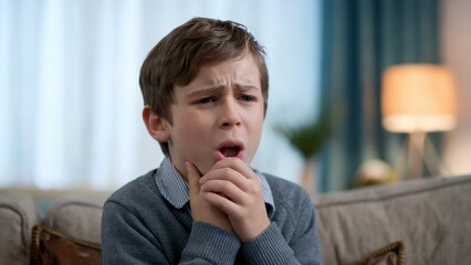 Concerned young boy indoors. Cinematic medium shot. Expression of soreness. Health and emotion theme. Suitable for healthcare, family, and lifestyle designs. Closeup portrait with copy space.