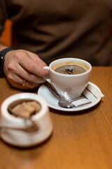 Close-up of an espresso cup in a man's hand