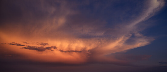 Dramatic sunset sky with orange colored clouds.