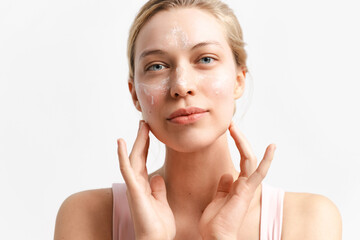 Blonde woman applying cosmetic soap foam portrait. Cheerful laughing millennial girl washing on face looking at camera.