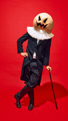 Figure with pumpkin head, dressed in Victorian-style black suit and white ruffed, leaning on cane,...