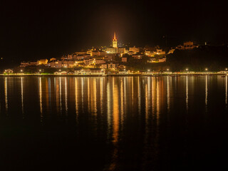 Fototapeta premium Historic Church Tower Dominates the Skyline of a Seaside Village