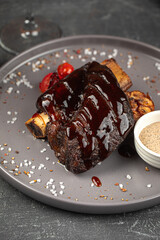 Portion of german grilled beef ribs with baked garlic and sauce