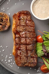 Closeup on portion of grilled beef steak with garlic and sauce
