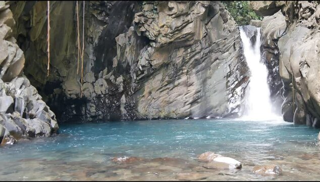 Saut d'eau du matouba, horizontal 4 K video of scenic y shaped cascade in Saint Claude, Basse Terre, Guadeloupe with blue natural pond in the rocks