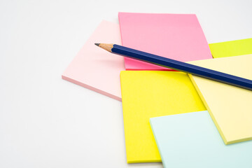 Pencil on blank colorful sticky note isolated on white background. Copy space.