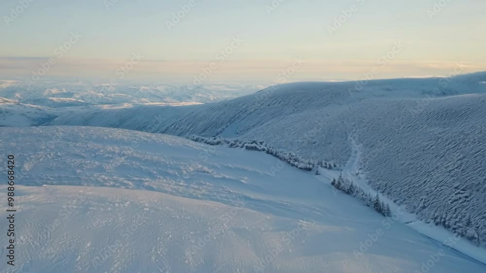 Poster the sun is setting over a snow covered mountain range, casting long shadows across the pristine snow