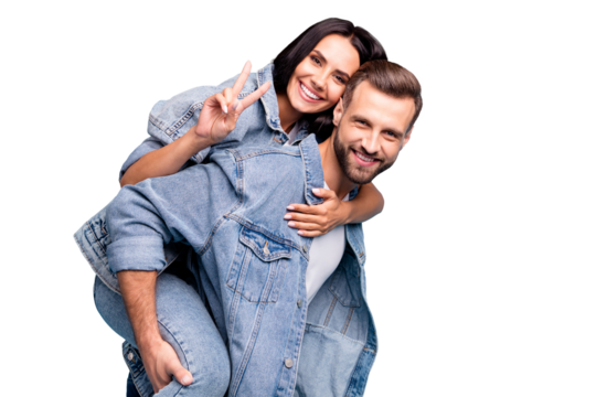 Portrait of cute man carrying his sweetheart making v-signs wearing denim jeans jacket isolated over blue background