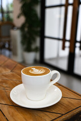 A cup of hot latte coffee on the table for breakfast
