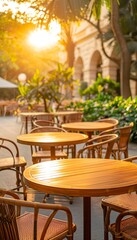 Obraz premium Empty tables and chairs at an outdoor cafe with warm evening light.