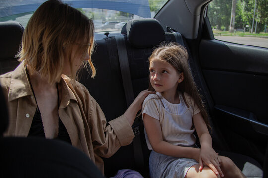 A woman and child share a backseat of a car