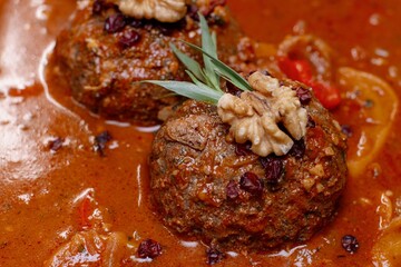 Traditional Persian Fesenjan with meatballs and walnuts.