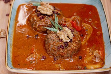 Traditional meatball dish in tomato sauce with walnut garnish