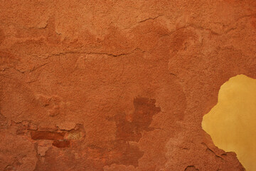 Weathered terracotta stucco wall texture with grunge plaster and copy space.