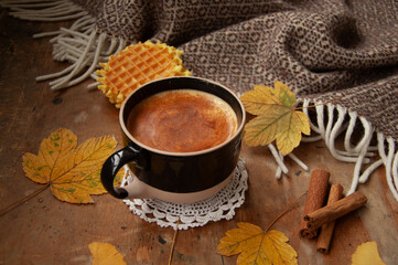 Cozy autumn coffee with leaves and a blanket