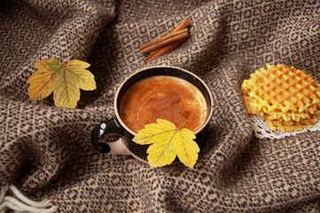 Cozy autumn coffee with leaves and a blanket