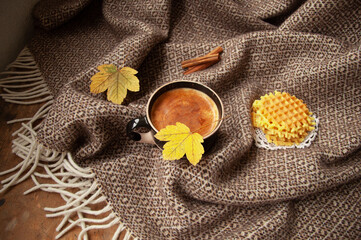 Cozy autumn coffee with leaves and a blanket