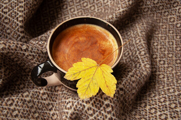 Cozy autumn coffee with leaves and a blanket