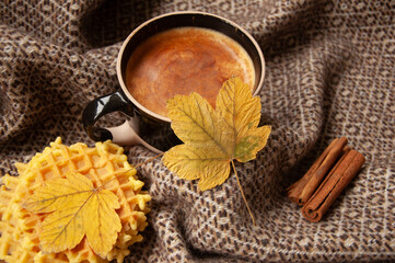Cozy autumn coffee with leaves and a blanket