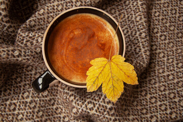 Cozy autumn coffee with leaves and a blanket