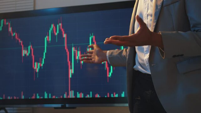 Financial advisor gesturing emphatically in front of a large screen, showcasing stock market data and trends. Dynamic hand movements emphasize key points in financial analysis