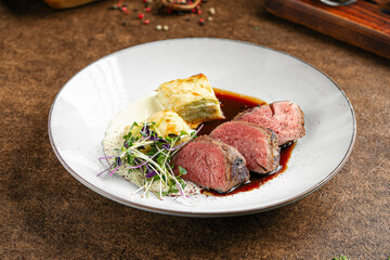 Portion of gourmet roast beef dish with potato gratin