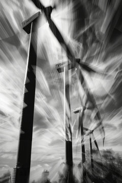 Windmills spin in wind at wind farm, creating dynamic and powerful scene. dramatic black and white filter enhances movement and energy of turbines