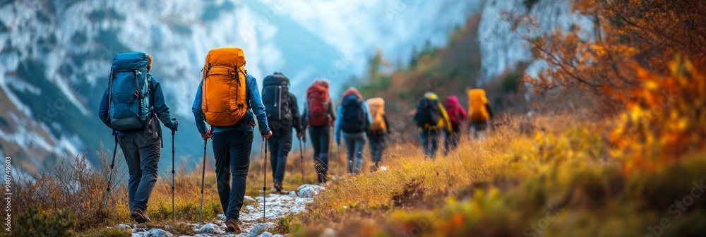 Wall mural mountain trail adventure, a group of hikers navigating a winding path, surrounded by a softly blurre