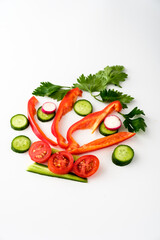 Vibrant arrangement of fresh vegetables showcasing cucumbers, tomatoes, radishes, and red peppers on a bright white background