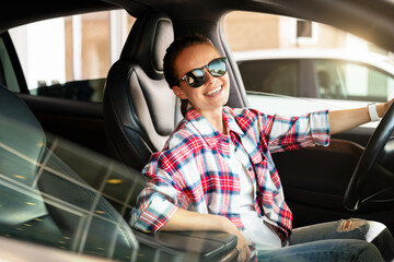 Happy woman inside car. Car-sharing, rental car service background. Car dealership.