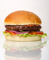 Juicy hamburger with fresh vegetables served on a soft bun, showcasing vibrant colors and textures in a bright setting