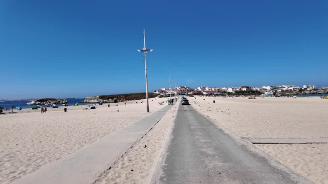 View of the Baleal Beach isthmus in Peniche, Portugal, connecting the mainland to the island, with sandy beaches and turquoise waters.
