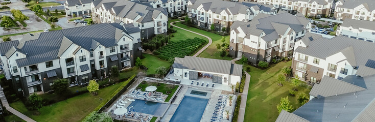 Panorama aerial view modern swimming pool spa in new development apartment complex, metal roofing, siding in fast growing area Pflugerville northeast of downtown Austin, Texas, housing market © trongnguyen
