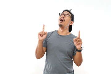 Amazed and surprised Asian man looking up and pointing with fingers and raised arms