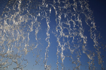 A mesmerizing capture of water splashing dramatically against a clear blue sky, showcasing the dynamic and fluid beauty of nature in motion.
