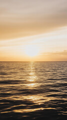 Obraz premium Tranquil ocean sunset with golden reflections on calm water, perfect for nature and relaxation themes