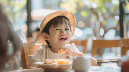 A cheerful child wearing a straw hat happily enjoys a meal at a sunlit café table, epitomizing joy and innocence in a light and airy setting.