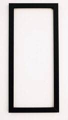 A black picture frame on a white wall.