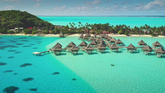 Turquoise lagoon Bora Bora island, French Polynesia, overwater bungalows, luxurious escape , tranquility, breathtaking ocean views. Remote wild nature paradise, exotic summer travel. Aerial drone shot