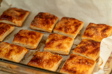 Puff cookies square with sugar in a baking dish. Delicious homemade cakes close-up