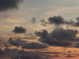 Airplane Silhouetted Against Dramatic Sunset Clouds