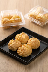 Freshly Baked Cream Puffs on a Black Plate