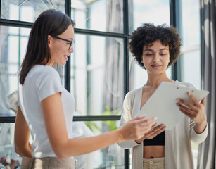 Two Businesswomen Shaking Hands In Modern Office