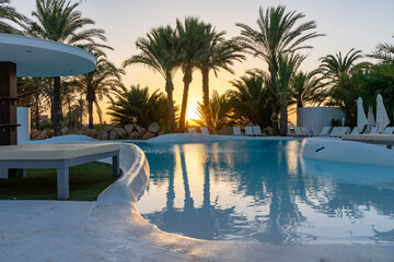 Relaxing pool surrounded by greenery and a beautiful sunset.