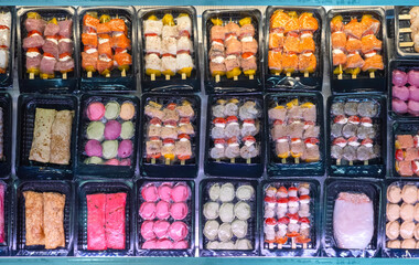 Fish snacks in vacuum packaging. Seafood store counter top view. Vacuuming food to avoid loss of...