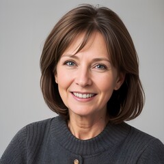 Smiling middle-aged woman with cheerful expression posing on neutral background
