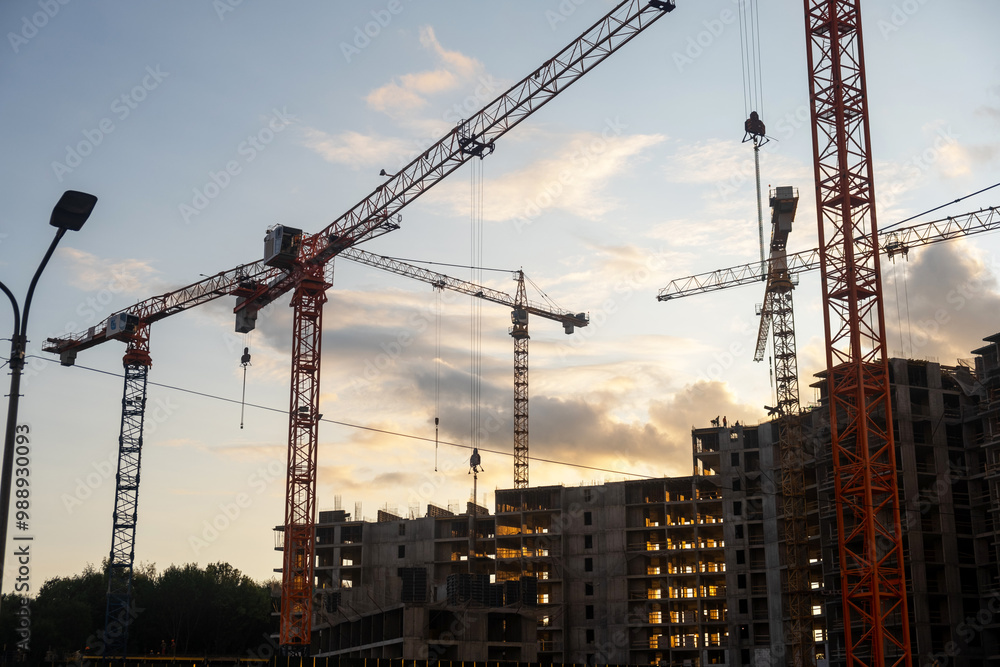 Poster multiple cranes operate efficiently at a bustling construction site, showcasing the progress of urba