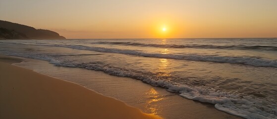 Fototapeta premium Sunset over a calm beach, and gentle waves lapping at the shore, panoramic view