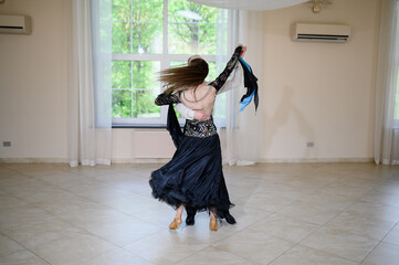 Graceful male and female ballroom dancers in stage costumes perform professional dance, twirling...