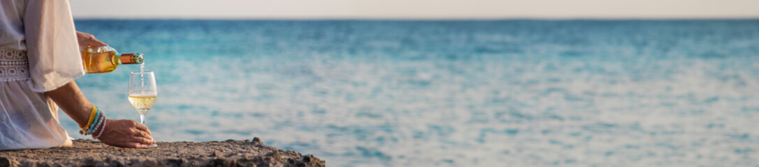 Woman with a glass of wine at the sea. Selective focus.